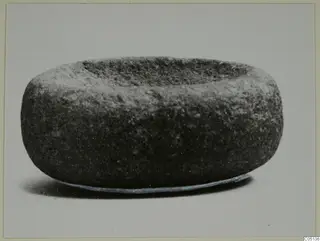 Stone mortar from Petra tou Limniti, squat and rounded, with a shallow hollow in its top.