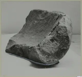Large stone mortar from Petra tou Limniti, a rough block with a deep hollow worn into its upper face.