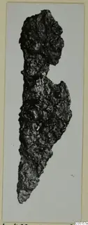 Corroded iron knife from the Kastros tombs at Lapithos, shown on a card mount.