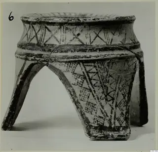 Pottery White Painted I amphora standing on three legs, with dark painted bands and hatched triangles