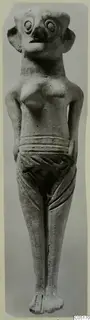 Standing figurine from Enkomi with large round eyes, a beak-like nose and protruding ears, shown frontally.