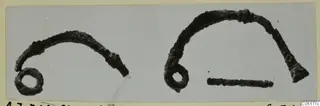 Bronze personal adornment with a loop: two corroded curved metal pieces, one ending in a small ring, on a grey card