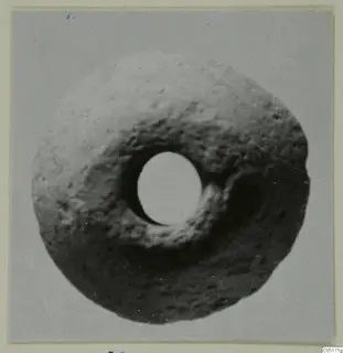 Terracotta ring-shaped object with a large central hole, shown from above against a plain grey background