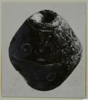 Stone spindle whorl from Lapithos, Kastros tombs, shown alone with a wide hole in its top.