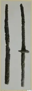 Two corroded iron weapons from the Kastros tombs at Lapithos, one with a cross-guard and grip