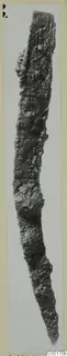 Long, narrow, heavily corroded iron tool, tapering to a point at its lower end.