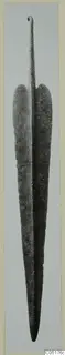 Metal blade from Lapithos, long and leaf-shaped, with a narrow tang ending in a small loop at the top.