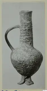 Jug with a tall neck, wavy relief bands, a loop handle and short feet, from Ayios Iakovos