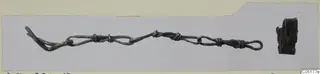 Two bronze objects on a card mount: a long twisted wire piece with loops and a small dark fragment at right.