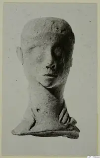 Terracotta head figurine with a long neck and flat base, shown frontally against a pale grey card.