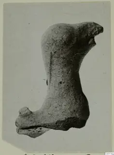 Fragment of a terracotta animal figurine, photographed on a pale card mount.