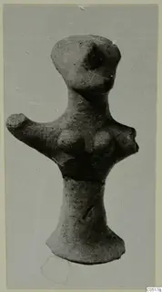 Terracotta figurine with a rounded head, an arm projecting to the left and a flared base, photographed on a grey card mount