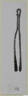 Metal tool with a looped top and two long prongs, a find from Ayios Iakovos, shown on a card mount.