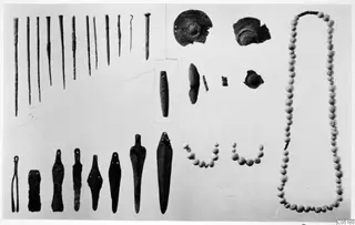 Bronze tools, pins, beads and small finds from Ayios Iakovos laid out on a pale background