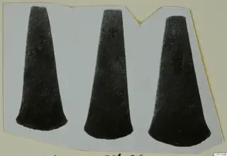 Three tapering axe blades shown side by side on a card mount, from the Vrysi tou Barba tombs at Lapithos