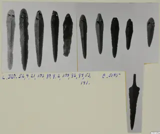 Bronze tools from Lapithos Tomb 320: ten pointed pieces and one blade, photographed on a mounted print