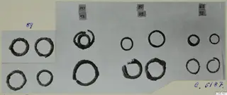 Corroded metal rings from Lapithos Tomb 316, arranged in groups on a mounted print with number labels