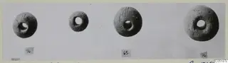 Four rounded objects with central holes from Lapithos Tomb 316, each with a small number label beneath