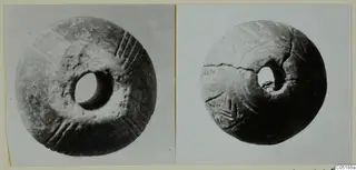 Two photographic views of a disc-shaped object with a central hole and incised radiating lines, mounted on a card