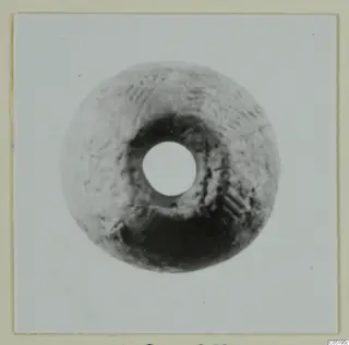 Disc-shaped find with a central hole, from Lapithos Tomb 313A, photographed face-on