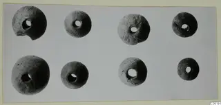Eight perforated round clay-like beads from Lapithos Tomb 313 B, four with incised lines above and four plain below