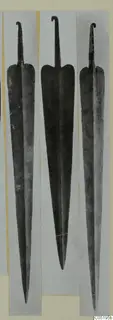 Three metal swords with tapering blades and hooked tangs, photographed side by side, from Lapithos, Vrysi tou Barba tombs.
