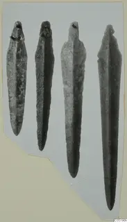Four bronze blades with pointed lower ends, from Lapithos Tomb 313 B, photographed on a grey card mount