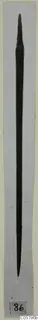 Long slender bronze tool from Lapithos Tomb 313, photographed vertically on grey card with number label 86