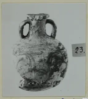 Small two-handled vessel with a rounded body and worn curved decoration, with a number label beside it