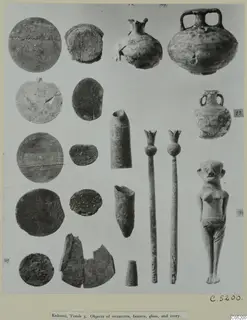 Small finds from Enkomi Tomb 3 laid out on a mount: discs, small vessels, tubular pieces, two rods and a standing figurine