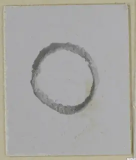 Dark grey ring with ragged edges on a pale card; no iron weapons or bronze tools visible