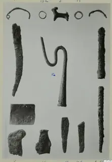 Metal finds from Lapithos Tomb 409: rings, hooks, long corroded rods, a flat plate and blade-like pieces laid out in rows