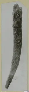 Heavily corroded iron object, long and slightly curved, from Lapithos Tomb 409
