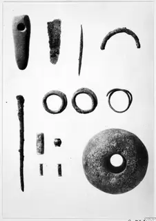 Bronze tools, rings and small finds from Ayios Iakovos laid out in rows on a pale background.