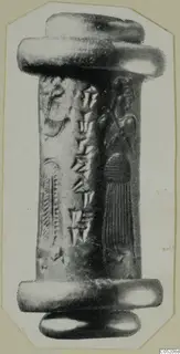 Cylinder seal standing upright, with carved wedge-shaped marks and a figure, shown on a photo mount
