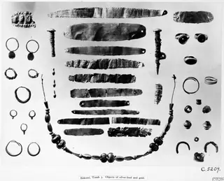 Bronze Age gold and silver objects from Enkomi, Tomb 3, laid out in rows: bands, hoop earrings, rings, pins and a bead necklace.