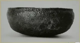 Dark, rounded bowl with a rough surface, shown from the side. Lapithos, Kastros tombs.