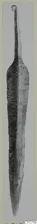 Long metal blade with a rounded top end and a tapering point, photographed upright on a card mount