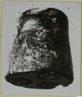 Cylinder seal in stone, photographed close up against a pale background