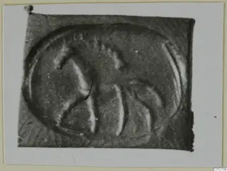 Close view of an engraved seal or gem with a curved design