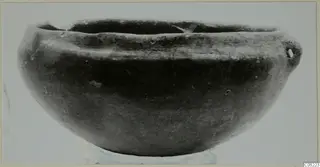Pottery Black Slip Ware bowl with a rounded body and a small handle on one side