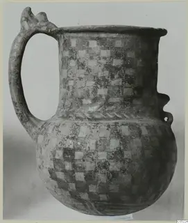 White Painted III-2 tankard with a checkerboard pattern of pale squares and a tall loop handle with a notched top.