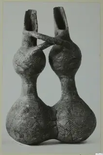 Red Polished III jug with two bulbous bodies, two spouts and a handle crossing between them, incised chevron decoration