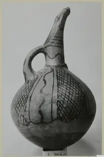 White Painted I - II jug with a beak-shaped spout, a loop handle and dark painted bands and hatching