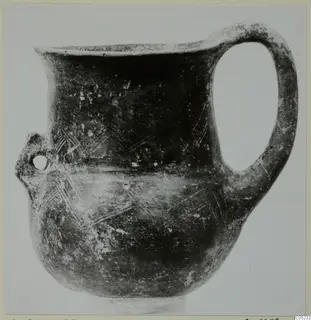 Black Slip Ware jug from Lapithos with a strap handle and incised hatched decoration on the body