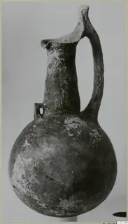 Black Slip Ware jug with a globular body, tall neck and strap handle