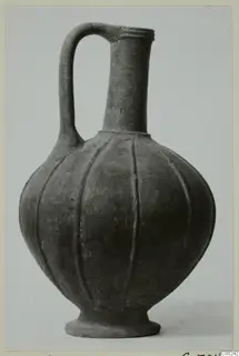 Jug with a single loop handle, a tall neck and a fluted, rounded body on a footed base.