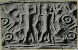Enlarged photograph of a rolled impression of a cylinder seal, with a central upright figure and ring motifs