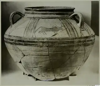 Large bichrome two-handled jar with painted bands and a running animal on the shoulder, shown in a front view.