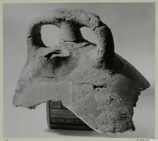 Fragment of coarse hand-made pottery with a thick loop handle pierced by two holes